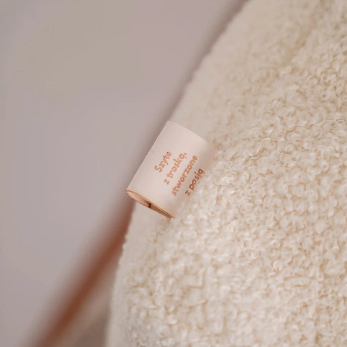 Detal na metkę w legowisku dla psa, tkanina boucle, kolor chałwa (kremowy). Nowoczesna, wysokiej jakości tkanina boucle z certyfikatami bezpieczeństwa.